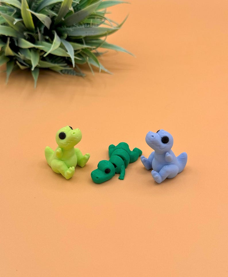 Sitting and laying t-rex 3D printed toys.