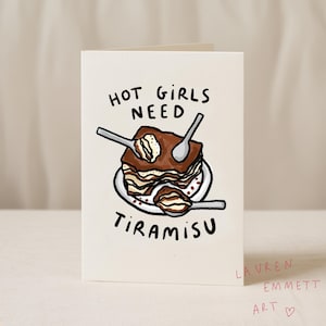 May include: A folded greeting card with the text "HOT GIRLS NEED TIRAMISU" above a drawing of tiramisu with spoons. The card is white with black and brown illustrations. The artist's name, "LAUREN EMMETT ART", is written in red.
