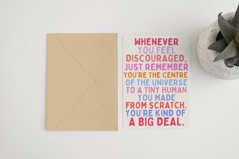 May include: A colorful card with the text "WHENEVER YOU FEEL DISCOURAGED, JUST REMEMBER YOU'RE THE CENTRE OF THE UNIVERSE TO A TINY HUMAN YOU MADE FROM SCRATCH. YOU'RE KIND OF A BIG DEAL."