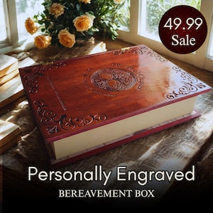 May include: A rectangular wooden box with a hinged lid, featuring a dark reddish-brown finish and intricate scrollwork engravings along the edges. The center of the lid displays a circular tree design with the text The Final Chapter engraved.