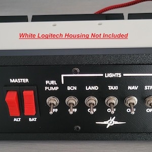 Könnte beinhalten: Schwarz-weißes Flugsimulator-Bedienfeld mit verschiedenen Schaltern und Knöpfen. Es verfügt über einen Schlüsselschalter, rote Kippschalter mit der Aufschrift "MASTER" und "ALT BAT" sowie mehrere Kippschalter für Lichter und Avionik. Text: "White Logitech Housing Not Included".