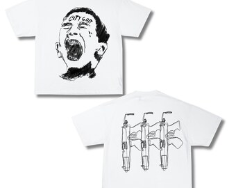 Op de afbeelding: Witte T-shirts met zwarte grafische ontwerpen. Eén shirt heeft een schets van een gezicht met de tekst "CITY GRIT". Het andere shirt heeft een lijntekening van drie geweren op de achterkant.