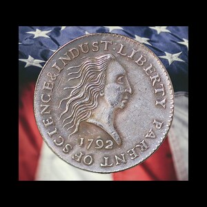 May include: A silver coin with the profile of a woman, the text "SCIENCE & INDUSTRY LIBERTY PATENT OF 1792" is engraved around the edge. The coin is set against a backdrop of the American flag.
