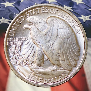 May include: A silver Half Dollar coin featuring an eagle with outstretched wings, surrounded by the words "UNITED STATES OF AMERICA" and "HALF DOLLAR." The coin is set against a backdrop of the American flag.