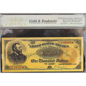 May include: A gold-colored banknote encased in a protective sleeve. The note features a portrait of a man on the left and the text "One Thousand Dollars" in the center. The certificate of authenticity reads "Gold & Banknote".