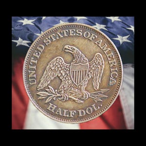 Pu&ograve; includere: Primo piano dettagliato di un'antica moneta Half Dollar. La moneta presenta un'aquila con le ali spiegate, uno scudo e le scritte "UNITED STATES OF AMERICA" e "HALF DOL." Lo sfondo &egrave; una bandiera americana sfocata.