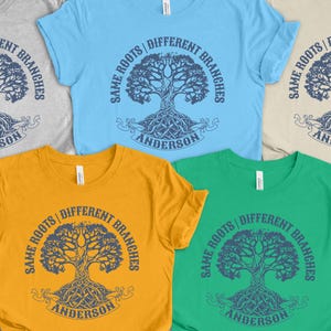 May include: Several crew neck t-shirts in shades of grey, blue, yellow, green, and beige. Each shirt displays a tree design with the words "Same Roots, Different Branches" and the name "Anderson".