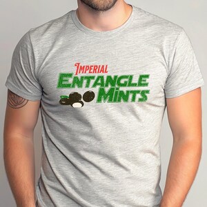 May include: Athletic heather gray t-shirt with the text "Imperial Entangle Mints" in green and red. The shirt features a graphic of two dark brown mint candies with a white center.