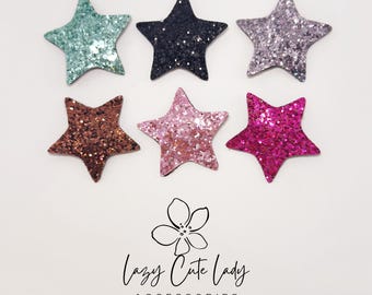 May include: Six glitter star-shaped accessories in various colors: teal, black, lavender, brown, pink, and magenta. The accessories are arranged on a white background. The text "Lazy Cute Lady Accessories" is at the bottom.