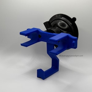 May include: A blue plastic device with a black suction cup base. The device has a hook shape and two angled arms. The text "@cleanupyourcockpit.com" is visible on the device.