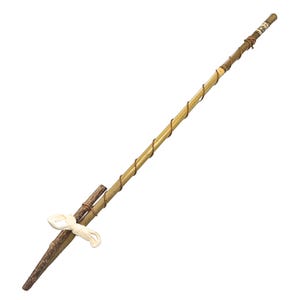 May include: A long, thin, brown wooden stick with a brown cord wrapped around it. The stick has a smaller, brown wooden piece attached to the end, secured with a white string.