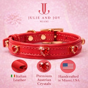 May include: A red leather dog collar with gold-tone metal hardware and heart-shaped red crystal embellishments. The collar has the text "JULIE AND JOY MIAMI". The image also includes text that says "Italian Leather", "Premium Austrian Crystals", and "Handcrafted in Miami, USA".