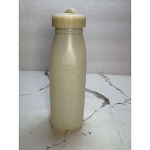 May include: A vintage, off-white plastic bottle with a matching cap. The bottle has a cylindrical shape with a slightly textured surface and a rounded base. The cap has a small loop for easy opening. The word "DAVOL" is embossed on the bottle.