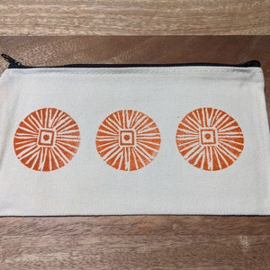 Estuche con cremallera con diseños de sellos naranjas tallados a mano