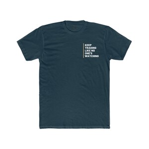 Könnte beinhalten: Ein dunkelblaues T-Shirt mit dem Text "KEEP TRADING LIKE NO ONE'S WATCHING" in weiß und einer gelben Linie auf der Vorderseite.