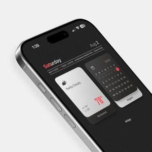 Puede incluir: Pantalla de smartphone que muestra un widget del tiempo con "Parcialmente nublado" y 25.5°C. Un widget de calendario muestra agosto de 2025. La hora es 1:39. El teléfono es plateado y negro.