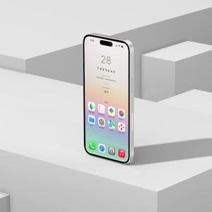 Puede incluir: Un smartphone plateado con una pantalla negra que muestra la fecha, la hora y los iconos de las aplicaciones. La pantalla muestra "28 MARTES" y "45&deg;F". El tel&eacute;fono est&aacute; colocado sobre una superficie geom&eacute;trica blanca.