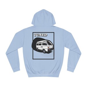 May include: A light blue hoodie with a white van illustration and the word "TUNED" in black text on the back.