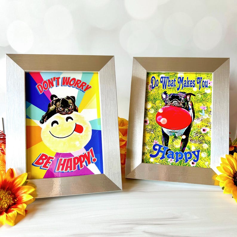 May include: Two framed prints with motivational quotes and images of pugs. The first print has a rainbow background with the text "Don't Worry Be Happy!" and a pug with a smiley face. The second print has a green background with the text "Do What Makes You Happy" and a pug holding a red frisbee.