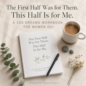 以下が含まれることがあります： 「The First Half Was for Them. This Half Is for Me. A 100 Dreams Workbook for Women 50+」と書かれた白いワークブック。黒いペン、コーヒーカップ、2つの小さな灰色の石、ユーカリの枝、ドライフラワーがベージュの布の上に置かれています。