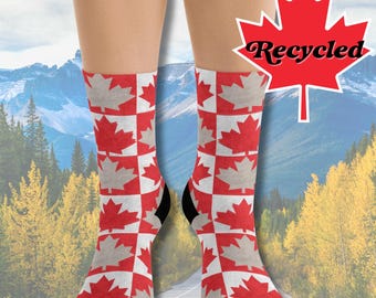 May include: A pair of red and white socks with a Canadian flag pattern. The socks are made from recycled materials and feature a black cuff.