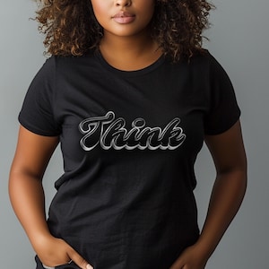 May include: A black t-shirt with the word "Think" printed in a stylized, 3D-like font with a silver outline.