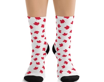 May include: White socks with a pattern of red maple leaves. The socks have black heels and toes. The maple leaf design is a nod to Canadian culture and heritage.