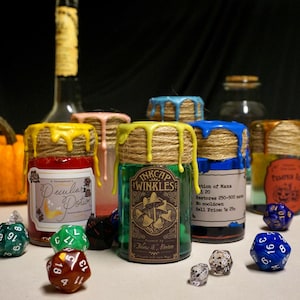 Könnte beinhalten: Mehrere Gläser mit farbigen Wachstropfen und mit Schnur umwickelten Deckeln werden gezeigt. Die Gläser haben Etiketten mit Texten wie "Peculiar Potion" und "Inkcap Winkles". Verschiedene Würfel sind um die Gläser herum verstreut.
