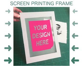 May include: White screen printing frame with a pink paper insert that reads "YOUR DESIGN HERE." A printed image is visible to the right. The text "SCREEN PRINTING FRAME" is at the top.