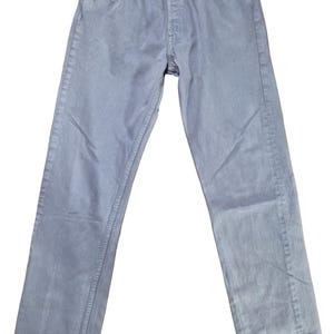 May include: Pale blue denim jeans with a button fly and five-pocket design. The jeans have a straight leg fit. The jeans are a light wash and have a faded appearance. The jeans are made of a durable denim material.