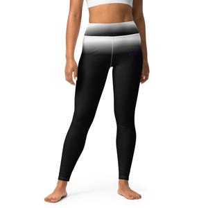 Könnte beinhalten: Schwarz-weiß Ombre-Leggings. Die Leggings gehen von Weiß oben nach Schwarz unten über. Ein kleines lila Logo ist auf dem rechten Bein sichtbar. Diese High-Waist-Leggings sind auf Komfort und Stil ausgelegt.
