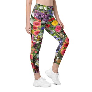 Könnte beinhalten: Bunte Blumenleggings mit einer Vielzahl von Blumen in den Farben Rosa, Lila, Gelb und Rot. Die Leggings sind ein lebendiges und auffälliges Kleidungsstück.