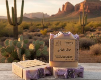 May include: Three rectangular bars of lavender soap with purple swirls and dried lavender buds on top. Each bar features a tan paper label printed with the text Robin's Soapery, Lavender, Handmade Coconut Milk Soap, Infused with Reiki Energy, 4.5 oz / 127 g.
