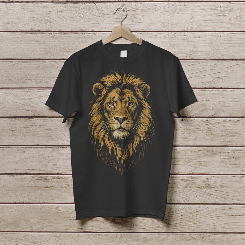 May include: Black t-shirt featuring a detailed illustration of a lion's head with a golden mane. The lion's face is centered, with a focused gaze. The design is printed on a black, short-sleeved tee shirt.
