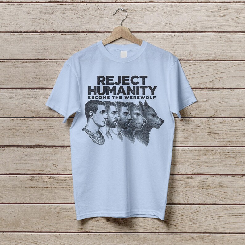May include: Light blue t-shirt with a black graphic print of a man transforming into a werewolf. The text on the shirt reads "Reject Humanity Become the Werewolf".