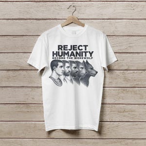 May include: White t-shirt with a black and white graphic print of a man transforming into a werewolf. The text on the shirt reads "Reject Humanity Become the Werewolf".