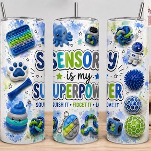 May include: A white tumbler with a stainless steel straw, decorated with sensory toys and the text "Sensory is my Superpower." The design includes a blue and green color scheme with stars and hearts.