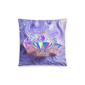 May include: A square throw pillow featuring a swirling lavender and purple liquid background. Centered are three ornate, iridescent, diamond-shaped crowns with gold filigree detailing and multi-colored gemstone accents that shimmer with blue, pink, and yellow hues.