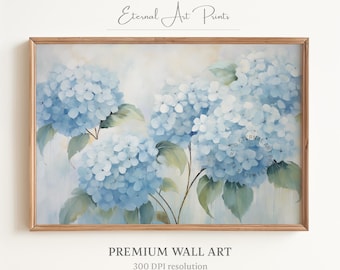 Puede incluir: Una pintura de hortensias azules con hojas verdes sobre un fondo blanco. La pintura está enmarcada en un marco de madera claro.