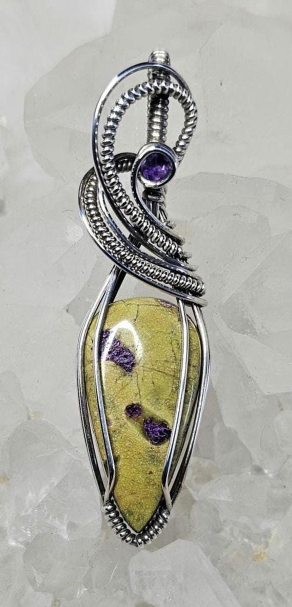 Atlantisite accented with a faceted Amethyst. Wrapped in Sterling Silver