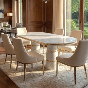 May include: A marble-topped oval dining table with a gold-accented base is surrounded by six upholstered chairs with gold legs. The chairs and table are set on a patterned rug in a well-lit dining room.