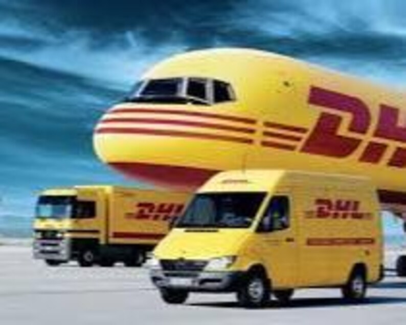 Pu&ograve; includere: Un aereo, un camion e un furgone gialli DHL sono parcheggiati su una pista. I veicoli hanno il logo DHL in rosso. L'aereo &egrave; sullo sfondo con il camion e il furgone in primo piano.