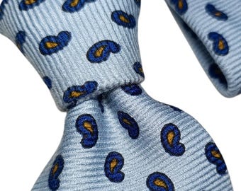 May include: A light blue necktie with a repeating paisley pattern in navy blue and gold. The tie is knotted, showcasing the fabric's texture and design. The paisley pattern is evenly spaced across the tie's surface.