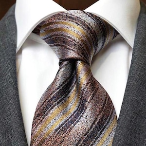 Peut inclure: Gros plan d'une cravate à motifs avec une chemise à col blanc et une veste de costume grise. La cravate présente des rayures diagonales dans les tons marron, or et bleu. La veste de costume est de couleur grise unie.