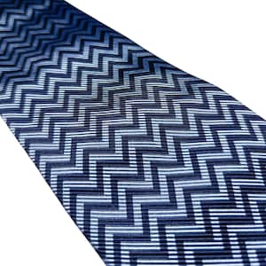 May include: A blue tie with a geometric zigzag pattern. The tie features a repeating design of navy, light blue, and white lines. The fabric has a subtle sheen, and the pattern is consistent across the tie.
