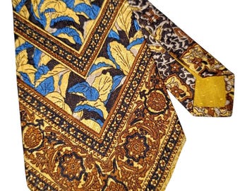May include: A patterned necktie featuring a repeating floral design in yellow, blue, and brown. The tie has a detailed border with a geometric pattern. The tie is made of a shiny material.