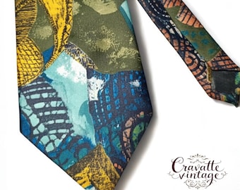 Pode incluir: Uma gravata vintage com um design de patchwork em tons de azul, verde e amarelo. A gravata apresenta padrões e formas abstratas. A gravata está em ângulo diagonalmente na moldura.
