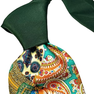 Puede incluir: Primer plano de una corbata. El nudo es de color verde oscuro liso, mientras que la parte delantera muestra un patrón vibrante. El patrón incorpora diseños de cachemira y florales en tonos amarillos, naranjas, azules y verdes.