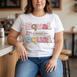 Puede incluir: Camiseta blanca con la frase "Equal means equal" en un diseño de patchwork. La palabra "Equal" está en rosa y tela estampada, y la palabra "means" es de color neutro. La camiseta se combina con unos vaqueros azules.