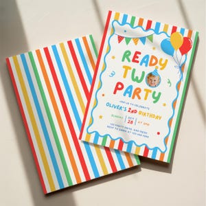 Op de afbeelding: Een rechthoekige verjaardagsuitnodiging met een kleurrijk verticaal gestreept patroon en een wit centraal gedeelte met een golvende blauwe rand. De tekst luidt READY TWO PARTY, JOIN US TO CELEBRATE OLIVER'S 2ND BIRTHDAY, SUNDAY OCT 28 AT 2PM.